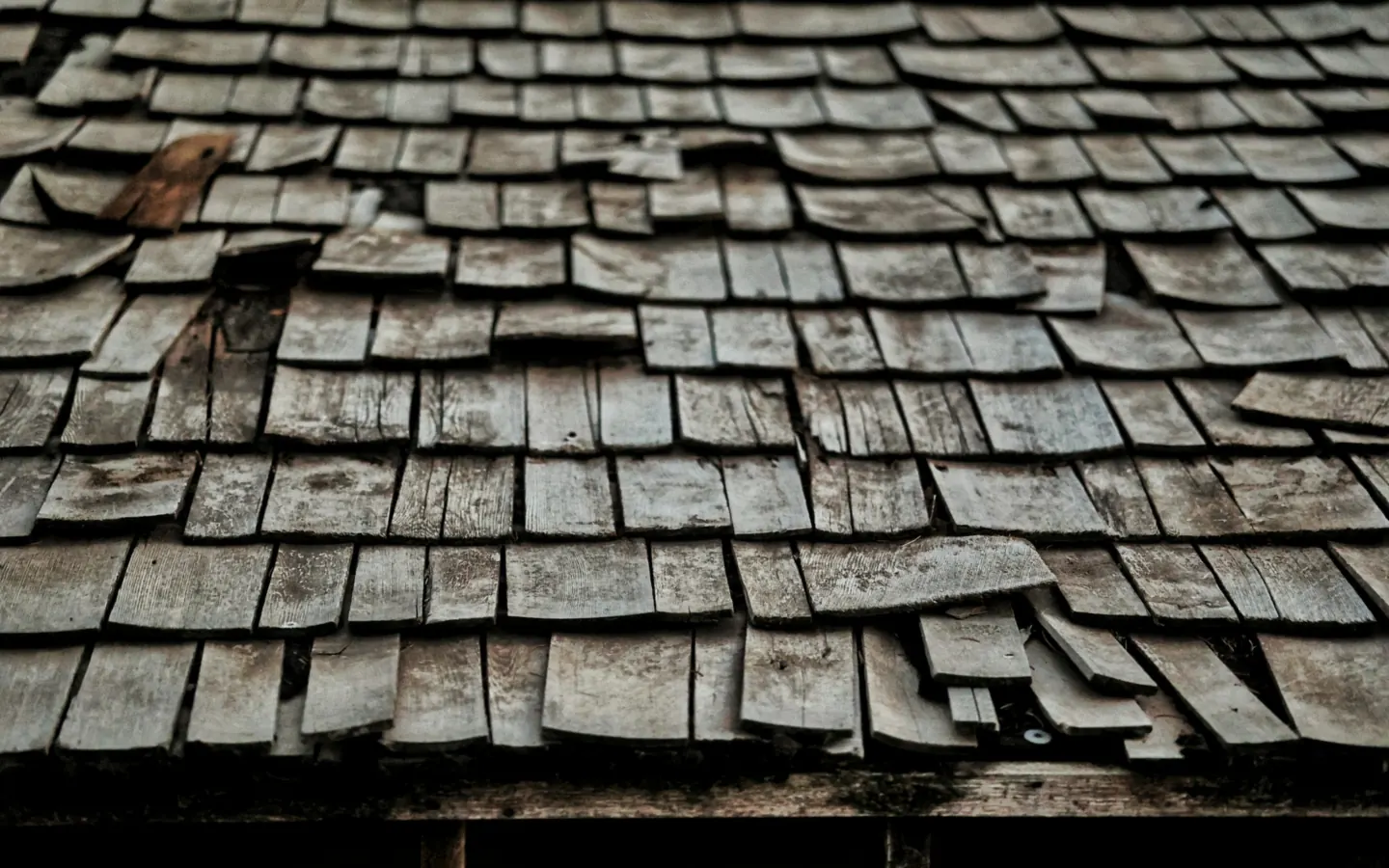 Demo photo: a worn cedar shake roof with lifted and broken shingles.